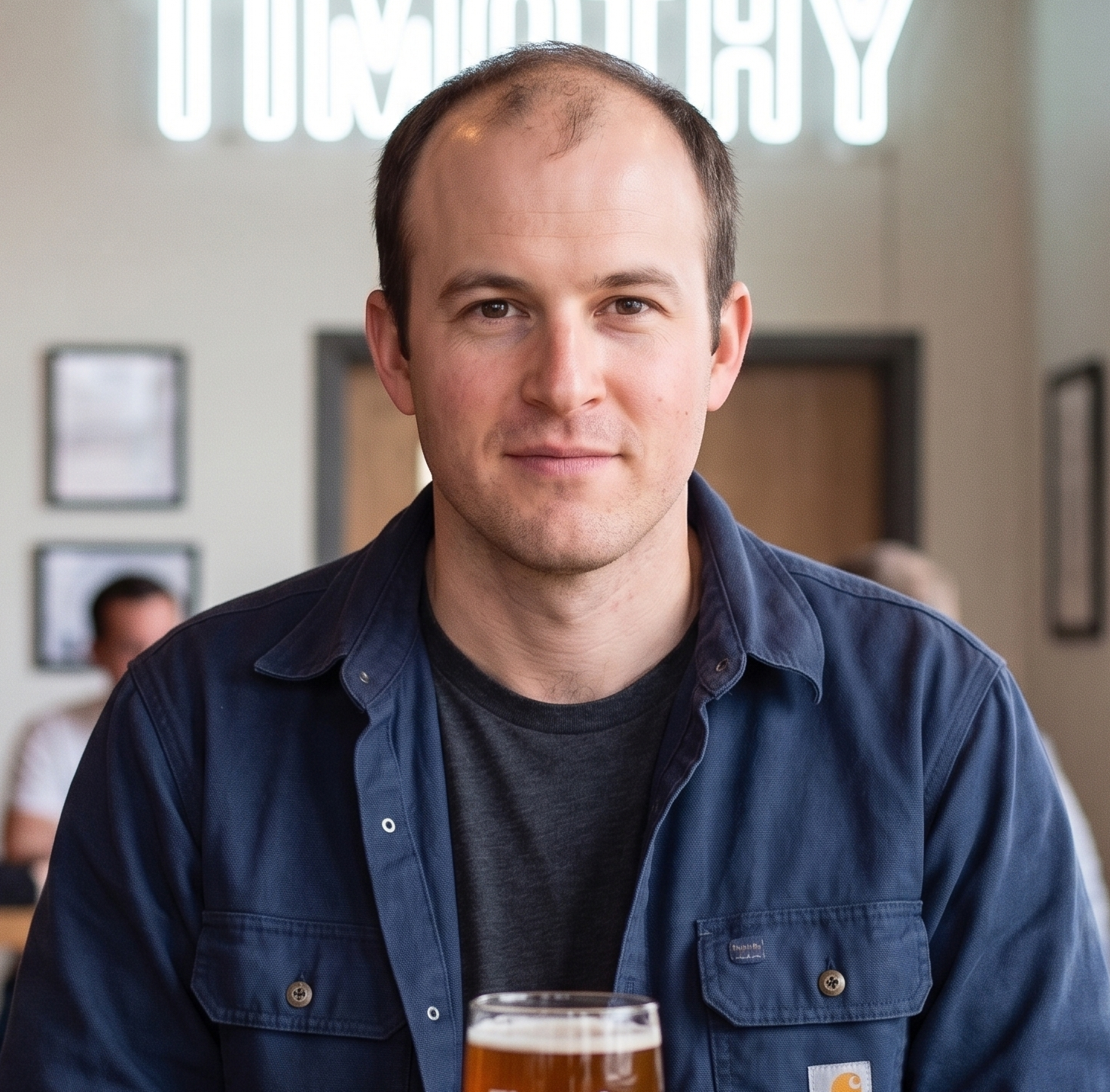 Timothy, the founder, holding a beer in his taproom